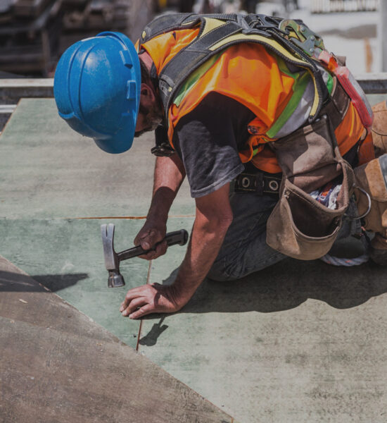 Man working with a hammer as a trade partner of a general contractor.